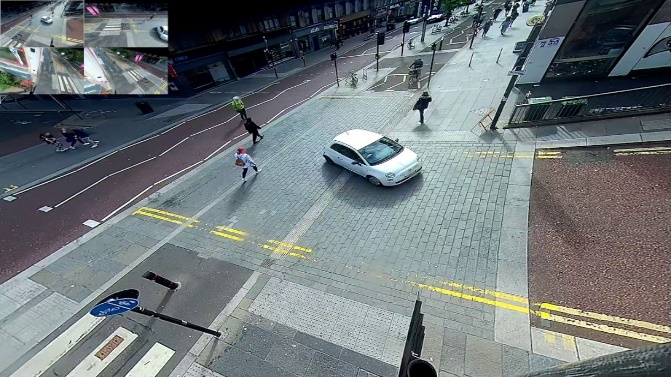 One of four images from cameras positioned above the junction. The first shows only the background image. The second has red lines superimposed indicating the paths of cars. The third has blue lines superimposed showing the paths of cyclists. The fourth has green and yellow lines superimposed showing the paths of pedestrians.