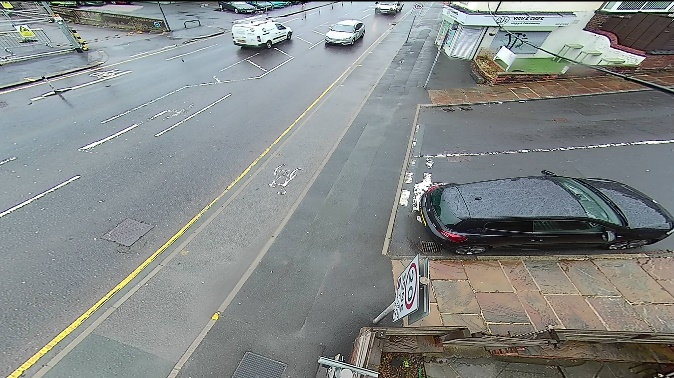 One of four images from cameras positioned above the junction. The first shows only the background image. The second has red lines superimposed indicating the paths of cars. The third has blue lines superimposed showing the paths of cyclists. The fourth has green and yellow lines superimposed showing the paths of pedestrians.