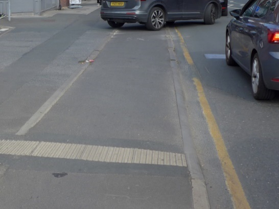 Photo showing transition between main road carriageway and drivable space is flush.