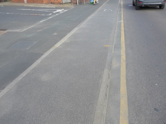 Photo showing transition between main road carriageway and drivable space is flush.