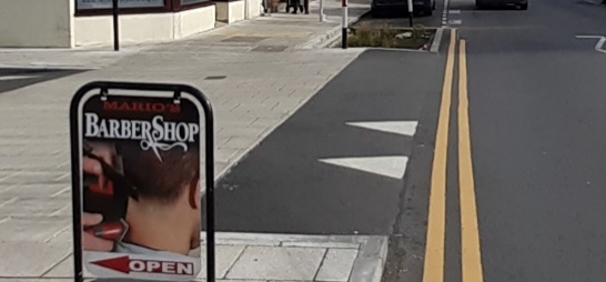 Photo showing a gentle asphalt ramp. There are two triangles marking this.